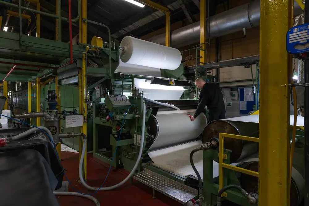 A quality checker looking at ambla fabrics on the machine